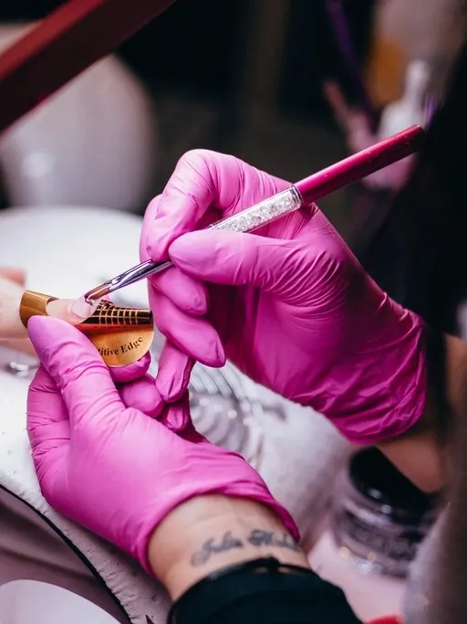 Manicurista con guantes haciendo un diseño